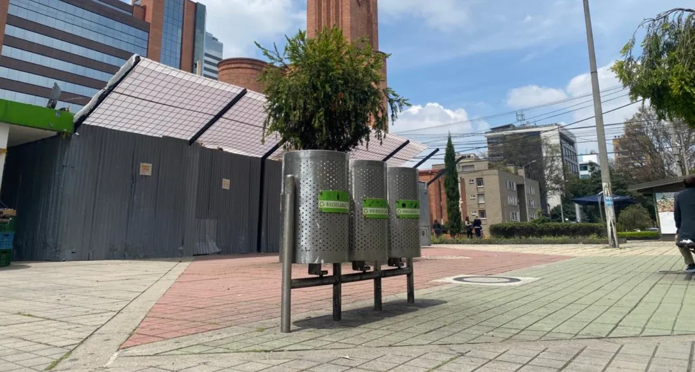 Trío de canecas metálicas instaladas en una plazoleta
